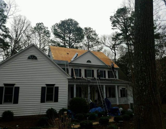 large house in the process of shingle extraction before new roof installation