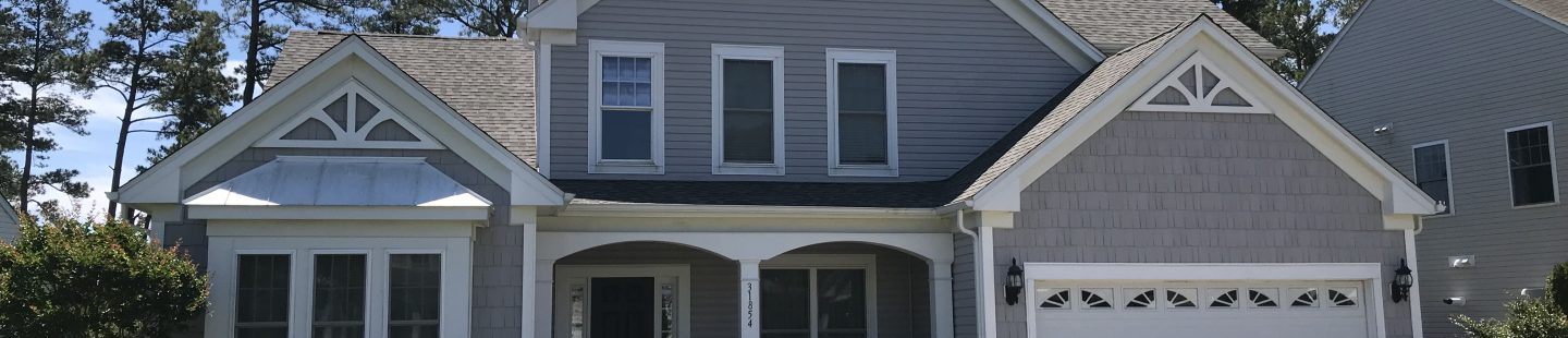large two story home with gray vinyl siding and asphalt roof