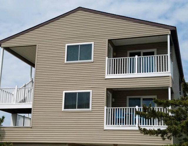 back view of a large beach condo with two square screen windows