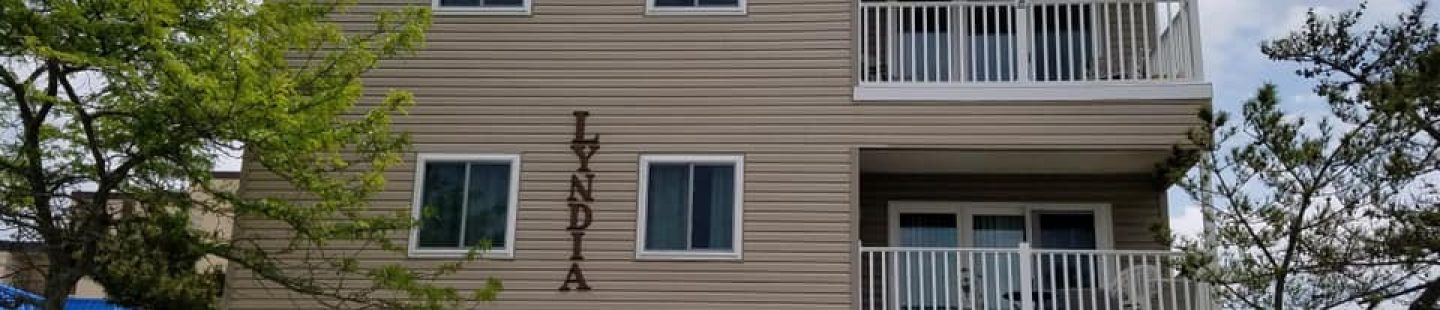 large beach condo with tan vinyl siding and four replaced windows